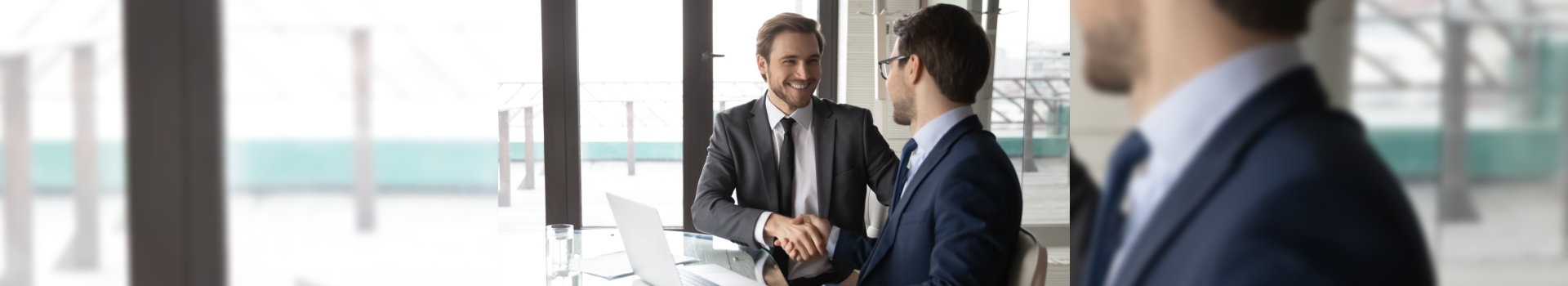 Smiling businessman shaking client hand, closing successful deal, sitting at table with laptop in office, satisfied hr manager hiring new employee, business partners handshaking at meeting