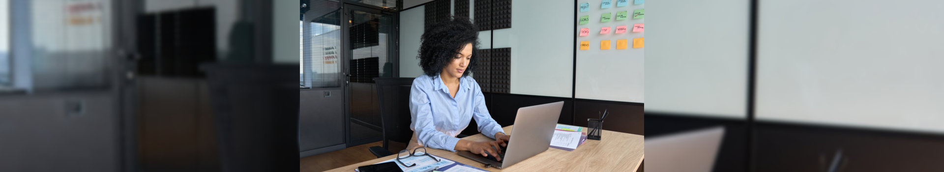 female ceo data analyst businesswoman sitting at desk working typing on laptop computer in contemporary corporation office. Business technologies concept.