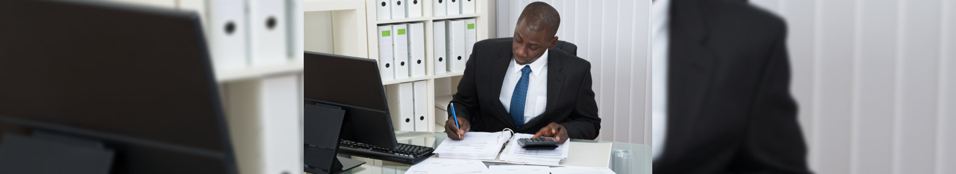 Businessman Calculating Finance Bills In Office